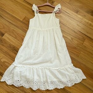 White sun dress, below the knee length.